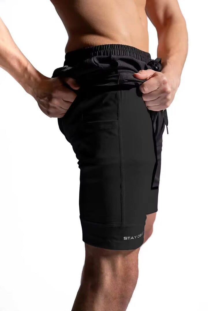Black drawstring shorts with elastic waistband, tied cords, and hem logo label.